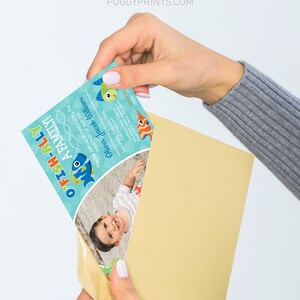 May include: A blue and green invitation card with a fish illustration and the text "O'FISH-ALLY A FAMILY!"  The card also includes a photo of a baby boy and the text "Please join us in celebrating the adoption of our son Oliver Jacob Williams Saturday, January 27th 2:00-4:00 pm Sophia's Sea Castle 123 Your Address Here Your City Here, ST 01234 RSOP PUGGYPRINTS.COM".