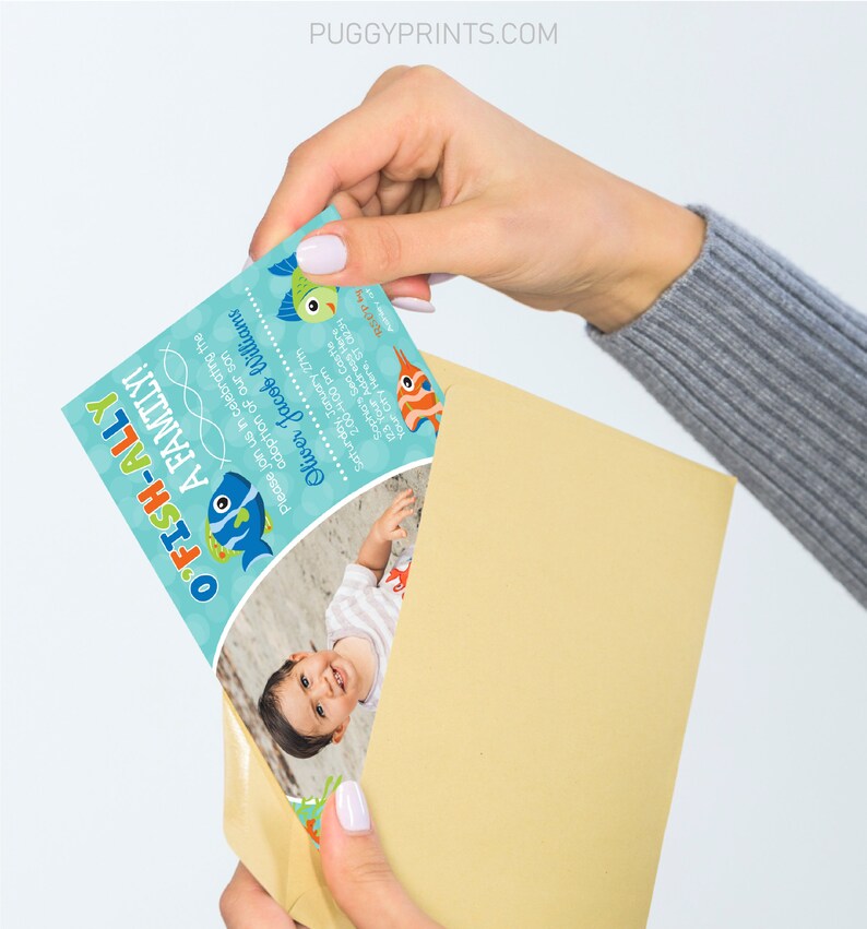May include: A blue and green invitation card with a fish illustration and the text "O'FISH-ALLY A FAMILY!"  The card also includes a photo of a baby boy and the text "Please join us in celebrating the adoption of our son Oliver Jacob Williams Saturday, January 27th 2:00-4:00 pm Sophia's Sea Castle 123 Your Address Here Your City Here, ST 01234 RSOP PUGGYPRINTS.COM".