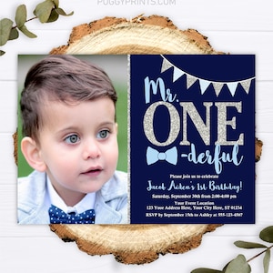 May include: A blue and silver first birthday party invitation with a photo of a baby boy wearing a bow tie. The invitation says "Mr. One-derful" and includes the baby's name, date, time, and RSVP information.