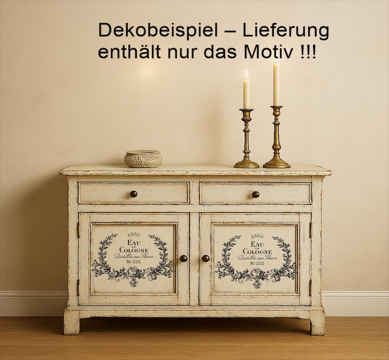 Puede incluir: Un aparador blanco roto envejecido con dos cajones y dos puertas. Las puertas presentan un dise&ntilde;o floral en blanco y negro con el texto "EAU COLOGNE". Dos candelabros de lat&oacute;n con velas encendidas y un peque&ntilde;o cuenco tejido est&aacute;n encima. El texto "Dekobeispiel - Lieferung enth&auml;lt nur das Motiv !!!" est&aacute; en la parte superior.