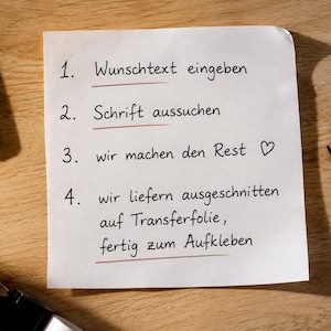 May include: A white square paper with four numbered steps in German text: 1. Wunschtext eingeben, 2. Schrift aussuchen, 3. wir machen den Rest, 4. wir liefern ausgeschnitten auf Transferfolie, fertig zum Aufkleben. A heart symbol follows step three.