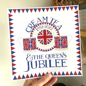 May include: A white card with a red, white, and blue border of triangles. The card says "Cream Tea 1952-2022 & The Queen's Jubilee" with two teacups and a plate with the Union Jack design.