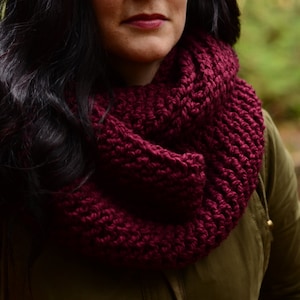 Peut inclure: Gros plan d'une femme portant une écharpe infinie de couleur bordeaux. L'écharpe est en tissu tricoté doux et est un excellent accessoire pour les saisons d'automne et d'hiver.