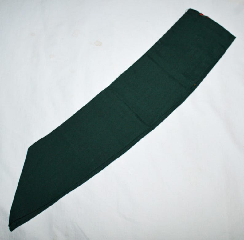 May include: A dark green fabric sash or belt, often used for scouting or other organisations.