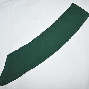 May include: A dark green fabric sash, often used for scouting or other organisations.