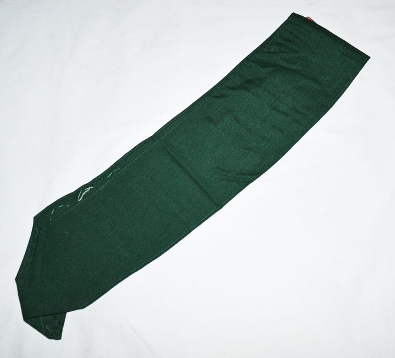 May include: A dark green fabric sash or belt, folded in half, with white stitching along the edges.