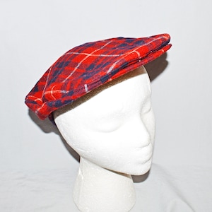 Puede incluir: Gorra de estilo newsboy a cuadros rojos, azules y blancos. La gorra est&aacute; hecha de tela tejida y tiene una corona redondeada y una visera peque&ntilde;a y r&iacute;gida. Se muestra sobre una cabeza de maniqu&iacute; blanca.