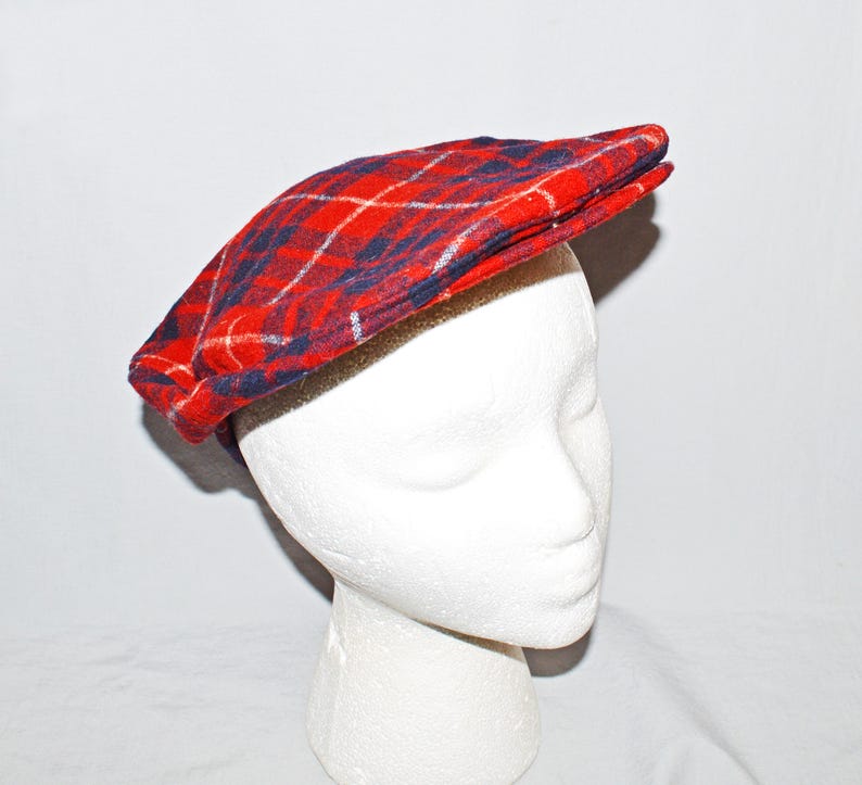 Puede incluir: Gorra de estilo newsboy a cuadros rojos, azules y blancos. La gorra est&aacute; hecha de tela tejida y tiene una corona redondeada y una visera peque&ntilde;a y r&iacute;gida. Se muestra sobre una cabeza de maniqu&iacute; blanca.