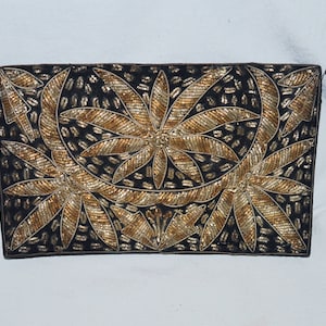 May include: A black velvet clutch bag with gold and silver embroidery of floral designs.