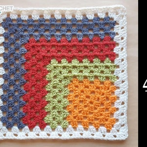May include: A crocheted granny square with a mitered design in shades of gray, red, green, orange, and white. The square measures 16 x 16 inches.