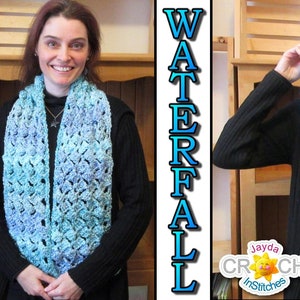 Op de afbeelding: Een blauwe en turquoise gehaakte sjaal met een waterval-steekpatroon. De sjaal wordt gedragen door een persoon en voor het gezicht gehouden. De tekst "Jayda Crochet InStitches" is zichtbaar in de afbeelding.