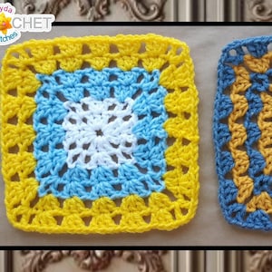 May include: Two crocheted squares, one with a white center surrounded by blue and yellow, the other with a yellow center surrounded by blue and gold.