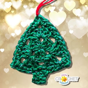 Peut inclure: Ornement de No&euml;l en forme de sapin de No&euml;l crochet&eacute; vert avec une ficelle rouge pour l'accrocher. L'ornement est sur un fond de c&oelig;urs blancs sur un fond dor&eacute;.