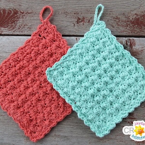 May include: Two crocheted dishcloths, one in coral and one in teal, with scalloped edges. The dishcloths are hanging on a wooden surface.