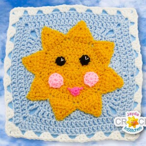 May include: A crocheted square featuring a yellow star-shaped sun with a pink nose and cheeks and black eyes. The sun is set against a blue background with a white border. The text "Jayda Crochet InStitches" is in the bottom right corner.