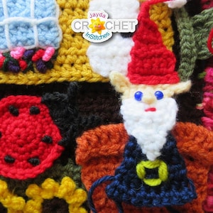 May include: A colorful crocheted wall hanging with a variety of shapes and designs, including a mushroom, a house, a ladybug, a gnome, and a flower. The wall hanging is made with different colored yarns, including red, white, blue, yellow, green, and brown.