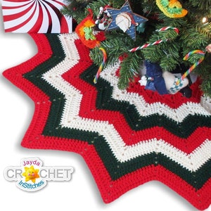 May include: A red, white, and green crocheted star-shaped Christmas tree skirt. The skirt is made with a chevron pattern and has a white border. The text "Jayda Crochet InStitches" is visible in the lower left corner of the image.