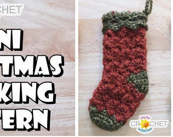 May include: A crochet pattern for a mini Christmas stocking. The stocking is red and green and has a textured design. The pattern is available on the website Jayda Crochet InStitches.