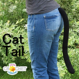 May include: A person wearing blue jeans with a black crocheted cat tail attached to the back of their waistband. The text "Cat Tail" is written in black letters on a green background. The text "Jayda Crochet Stitches" is written in white letters on a yellow sun with a red outline.