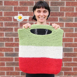 May include: A green, white, and red striped crochet tote bag with a large handle. The bag is made with a simple crochet stitch.