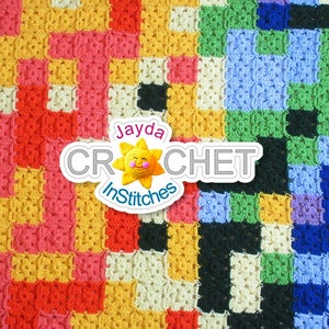 Puede incluir: Una manta de crochet colorida con un patrón cuadrado en tonos de rojo, amarillo, rosa, azul, verde y blanco. La manta tiene un logotipo en el centro que dice "Jayda Crochet InStitches".