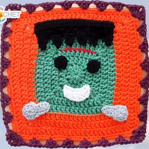Puede incluir: Un cuadrado tejido a crochet con un monstruo de Frankenstein verde con pelo negro, ojos negros, una sonrisa blanca y manos grises. El cuadrado está rodeado por un borde naranja con un borde festoneado morado.