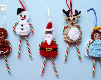 May include: A collection of five handmade crochet Christmas ornaments. The ornaments include a gingerbread man, snowman, Santa Claus, reindeer, and angel, each with candy cane legs and hanging loops.