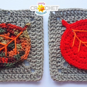 May include: Two crocheted squares with leaf appliqués. One square features a leaf in fall colors, the other a bright red leaf. Both leaves have orange stitching. The squares are a neutral gray color.