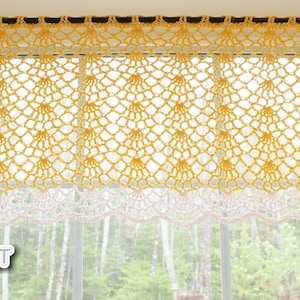 May include: A handmade yellow crochet window valance with a white scalloped edge. The valance is suspended from a dark rod and features a delicate, openwork design. The window behind the valance shows a blurred outdoor scene.