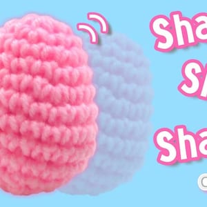 May include: A pink crocheted egg with a textured surface. The egg is shaking back and forth. The text "Shake Shake Shake" is written in white letters on a pink background. The text "Jayda Crochet Institches" is written in white letters on a yellow star.