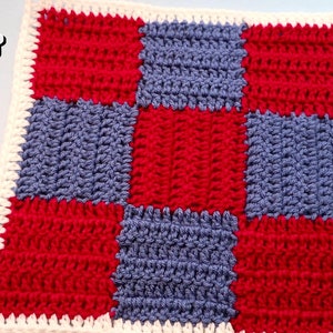 Puede incluir: Un cuadrado tejido a crochet con un patrón de tablero de ajedrez en rojo y azul. El cuadrado está bordeado con un borde tejido a crochet blanco.