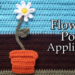 May include: A crocheted flower pot applique with a white daisy flower, green stem and leaves, and an orange pot. The applique is on a brown and blue crocheted background with the text "Flower Pot Applique" in white.