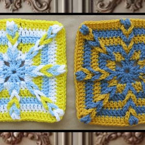 May include: Two crocheted squares with a starburst design. The square on the left is yellow, white, and blue. The square on the right is yellow and blue.