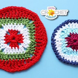 Puede incluir: Dos manteles individuales redondos de ganchillo, uno rojo, verde y blanco, y el otro azul, blanco y burdeos. Los manteles individuales están sobre un fondo azul claro.