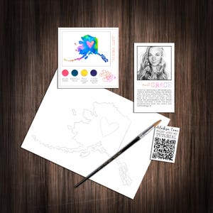 May include: A watercolor painting kit featuring a white card with an outline of Alaska and a heart, a reference card with a colorful Alaska map labeled "ALASKA LOVE", a paint brush, a biography card for Grace, and a tutorial card with a QR code.