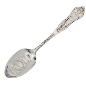 May include: A silver spoon with an ornate handle depicting a knight with a sword and shield. The spoon's bowl has engraved text and a crest. The text reads "Williamsport May 1906" and "Baldwin Commandery No 22".