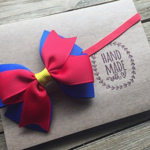 Snow White inspired headband adorable 3 inch hair bow in blue red and yellow on a fitted elastic band for babies and girls of all ages