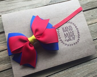 Snow White inspired headband adorable 3 inch hair bow in blue red and yellow on a fitted elastic band for babies and girls of all ages