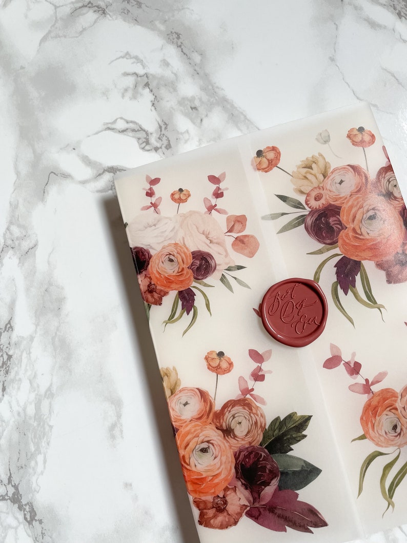 May include: A white envelope with a floral design in shades of orange, pink, and burgundy. The envelope has a red wax seal with the text "Just Do You" in white.
