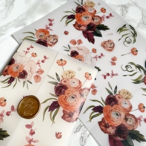 May include: Two sheets of clear vellum paper with a floral design. The design features a bouquet of burgundy, peach, and cream flowers with green leaves. The sheets are perfect for crafting, scrapbooking, or adding a touch of elegance to any project.