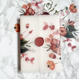 May include: A white envelope with a floral design in shades of pink, red, and green. A red wax seal with the text "Just Married" is on the front of the envelope.