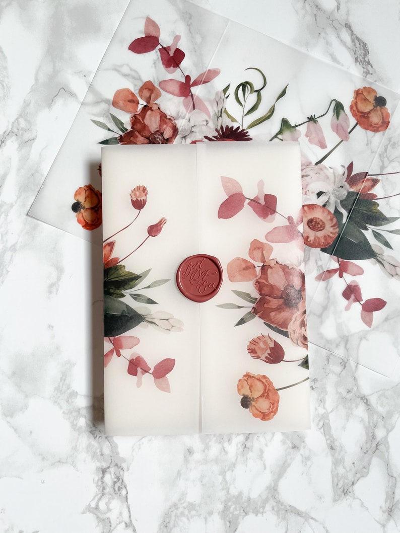 May include: A white envelope with a floral design in shades of pink, red, and green. A red wax seal with the text "Just Married" is on the front of the envelope.