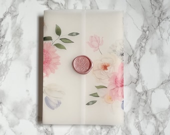 May include: A white envelope with a floral design and a pink wax seal. The seal has the letters "A & J" written on it.