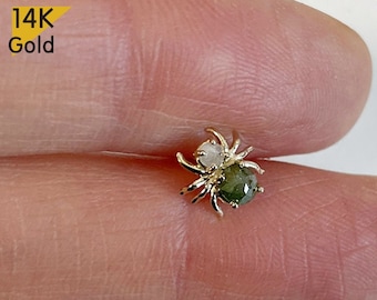 May include: 14K Gold spider earring with a green and white gemstone.