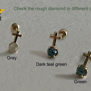 May include: Three 14K gold cross earrings with a rough diamond in the centre. The diamonds are grey, dark teal green, and green.
