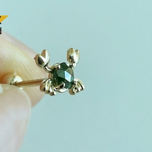 May include: 14K gold crab body jewellery with a green gemstone.