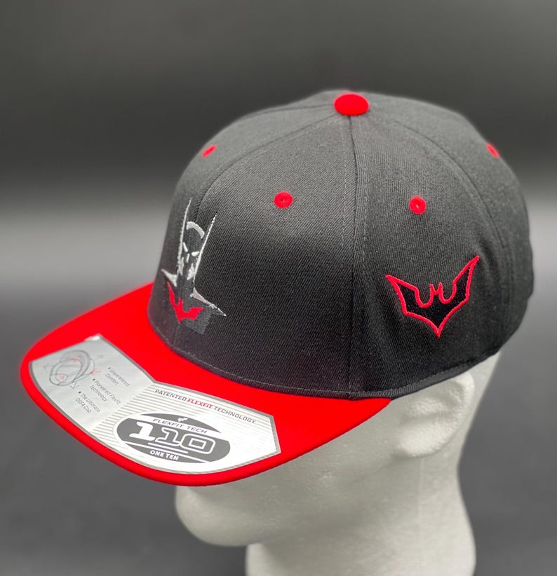 May include: Black and red baseball cap with a white embroidered logo of a bat and the text "Flexfit Tech 110 One Ten" on the underside of the brim.