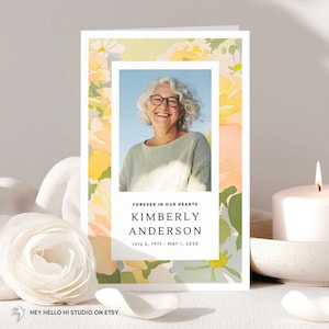 Könnte beinhalten: Eine Trauerkarte mit einem Foto einer lächelnden Frau, umrahmt von einem floralen Aquarelldesign in Gelb, Grün und Pfirsich. Der Text lautet "Forever in our hearts", der Name "Kimberly Anderson" und die Daten 2. Juli 1971 - 1. Mai 2025. Eine brennende Kerze und eine weiße Blume sind im Hintergrund.