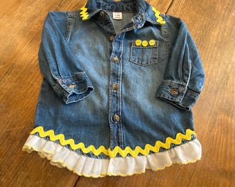 Girls Denim Shirt.   Toddler’s size 6-12 mos.   Denim accented in yellows.