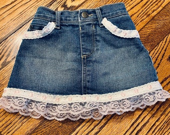 Toddler’s denim skirt.  Size 18 to 24  months. Girls Jean Skirt.  Embellished with pink lace. Toddler Girls Skirt